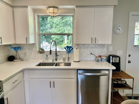 Back splash made from seashell and kitchen overlooking backyard.