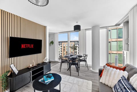 Spacious open-plan living area featuring a 50” smart TV and a plush, comfortable corner sofa, perfect for relaxing.