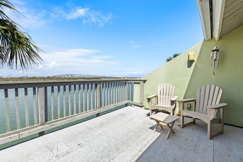 Unwind on your private waterfront balcony with comfortable Adirondack chairs, watching boats drift by while palm fronds sway in the coastal breeze.