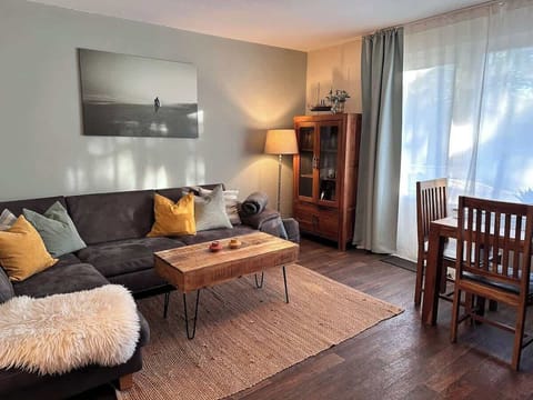 Gemütliches Ecksofa mit Kissen und Decken im Wohnzimmer. 