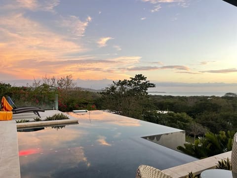 Enjoy the sunset sky, Pacific Ocean, and tropical dry forest treetop views