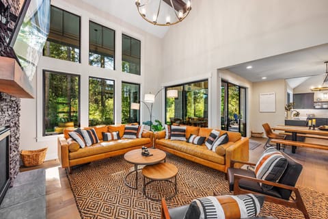 The floor-to-ceiling windows flood the space with natural light, showcasing breathtaking panoramic views of nature