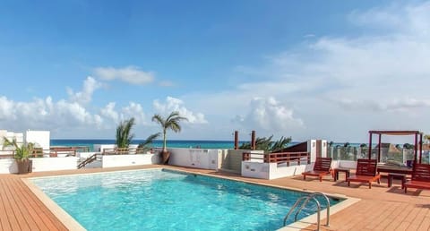 Rooftop pool area with ocean views and lounge chairs for relaxing.