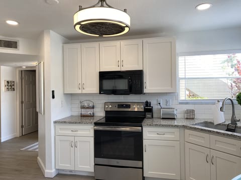 Kitchen with new cabinets, stainless steel appliances and granite countertops.