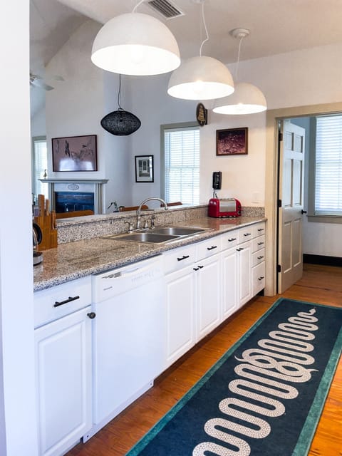 The kitchen has a full size fridge, gas cooktop and oven, dishwasher, and a full size sink that looks out through the porch doors onto Mobile Bay!
