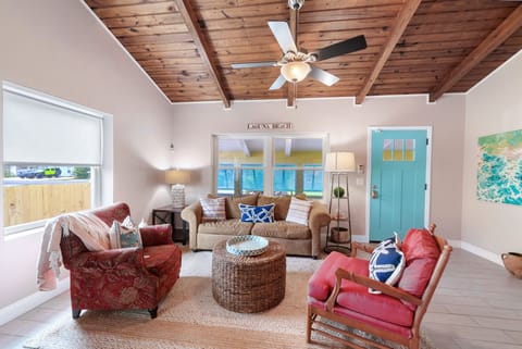 Relax in your coastal living room with beautiful wood ceilings, comfortable seating, and bright beach-inspired decor that instantly puts you in vacation mode.
