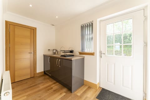 Utility room with washing machine and dishwasher. Rear door to garden.