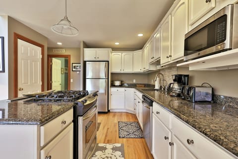 Fully equipped kitchen with granite countertops, refrigerator, gas range, and microwave