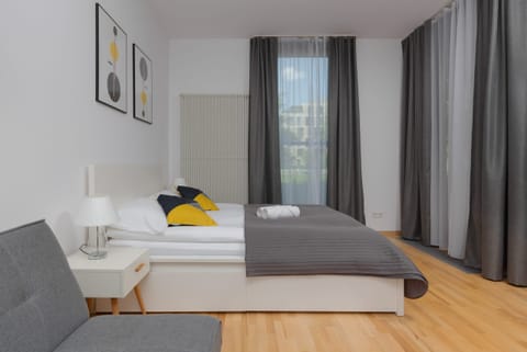 Bedroom featuring a large bed with gray bedding, decorative pillows, and modern wall art.
