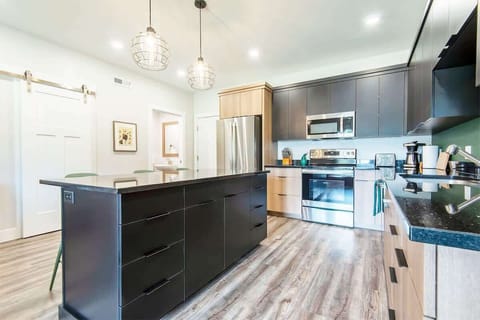 Fully equipped kitchen with brand new cookware set, knives, and coffee machine.