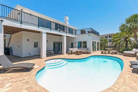 Large pool w/ curved edges, sun loungers, & space to relax poolside