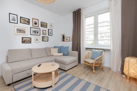 Cozy living room with a gray sofa, framed wall art, and a round wooden coffee table.
