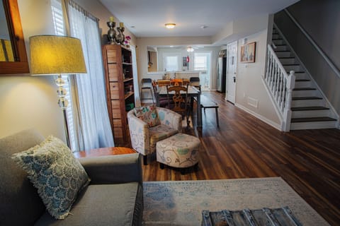Bright open living and dining space with warm wood floors and cozy seating