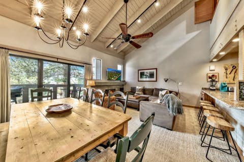 Gather around the rustic wooden dining table while your group enjoys the open-concept living space with vaulted ceilings and mountain views.