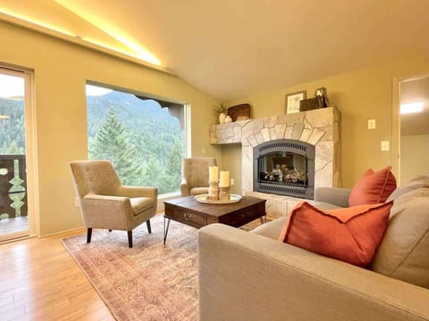 The living room in the Pacific Spruce Heights Suite is complete with a plush sofa and two sitting chairs, centered around a cozy gas fireplace, and of course, you can't miss those stunning views.