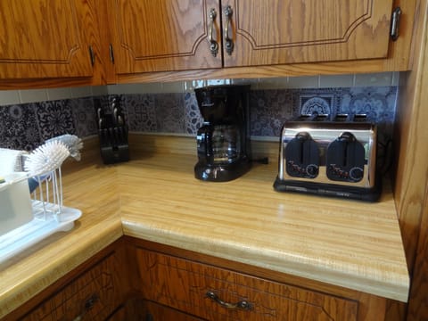 Kitchen with dining table, dishwasher, stove, fridge, microwave, Keurig and regular coffee pot, lots of cupboard space, dishes, pots, pans, silverware.