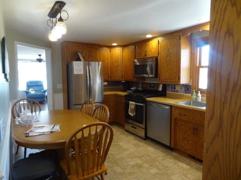 Kitchen with dining table, dishwasher, stove, fridge, microwave, Keurig and regular coffee pot, lots of cupboard space, dishes, pots, pans, silverware.