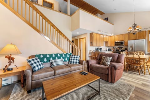Living area featuring hardwood floors, vaulted ceiling, flat screen TV, gas fireplace and access to the private balcony.