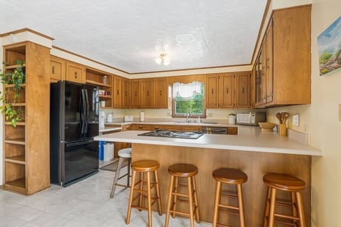 Full size kitchen featuring tons of countertop space, barstool seating, and a modern dining set for six.