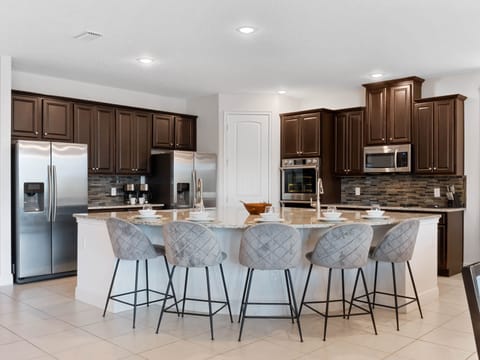 - Cook with ease in the modern kitchen featuring stainless steel appliances
- Granite counters and spacious island seating for family meals
- Orlando vacation rental with full kitchen for group stays