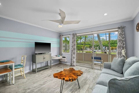 Unwind in your light filled living space featuring plush seating, coastal accents, and a private patio with lush garden views, a breezy island retreat you'll love calling home.