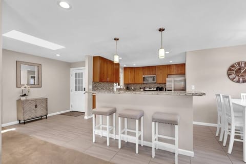 Dining area seats 6 comfortably around the table and offers 3 bar stools for extra seating.