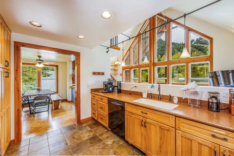 Spacious kitchen with modern appliances, ample cabinetry, and large windows offering abundant natural light and scenic views.