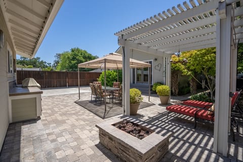 Gather under the pergola beside the fire pit