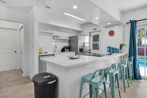 “Bright kitchen with island seating and pool access—ideal for dining and relaxing at your vacation rental.”