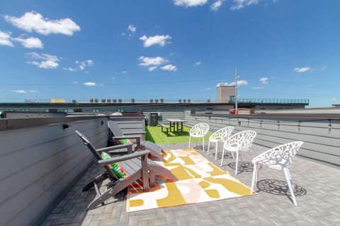 Rooftop patio with Adirondack chairs and a colorful rug — perfect for soaking up the sun