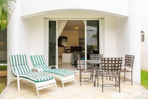 Outdoor patio with striped lounge chairs and a metal dining set for relaxing and dining.