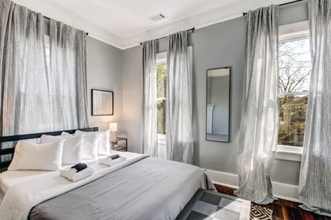 The first of two private bedrooms has a queen bed, ROKU TV, and a desk.