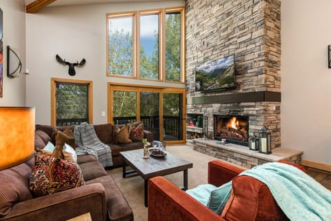 Living Room with plush furnishings, wood-burning fireplace, smart TV, and private balcony access