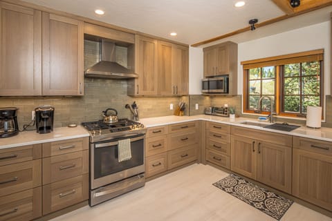 The kitchen is gorgeous with wooden cabinets, beautiful countertops and lovely backsplash | Main Level