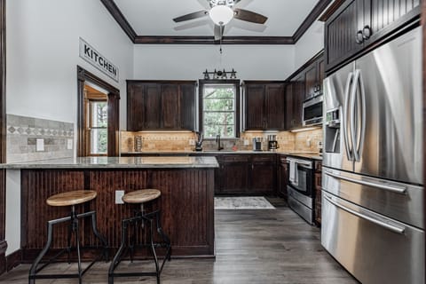 Kitchen with plenty of dishes, large fridge, and island, and pantry.