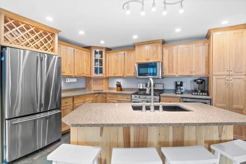 Fully equipped kitchen designed for culinary enthusiasts, featuring a central island with a sink for convenient meal preparation and all the necessary cooking essentials."