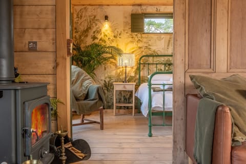 Olive Tree House, Sussex: A sliding barn door reveals the romantic bedroom suite