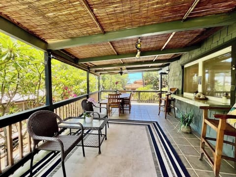 Dining al fresco upstairs with sounds of and partial view of ocean nearby.