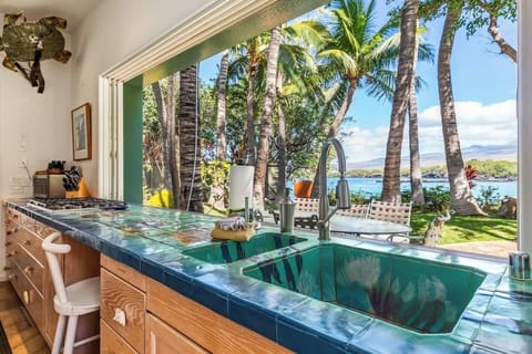 One of a kind kitchen and outdoor dining area looks out on sunny Kohala Coast