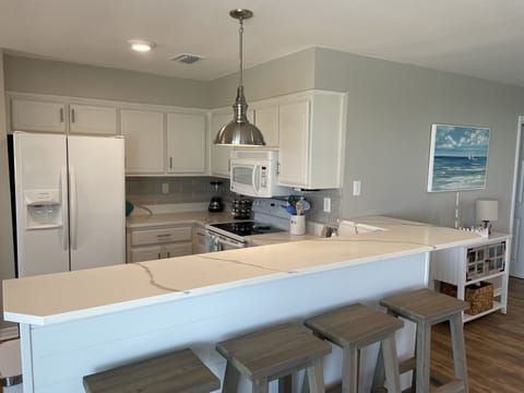 The rest of the kitchen with bar top and 4 stools 