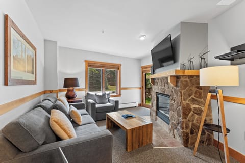 Sink into plush seating by your stone fireplace, where warm wood accents and soft lighting create the perfect retreat after your adventures.