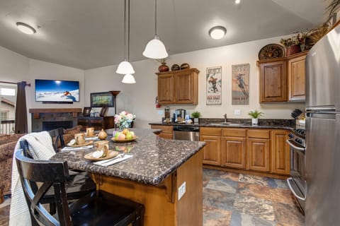 Fully Equipped Kitchen with stone countertops, stainless steel appliances, and island seating for three