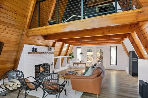 Living room space includes a 3 person sofa with 2 chairs and a gas fireplace.