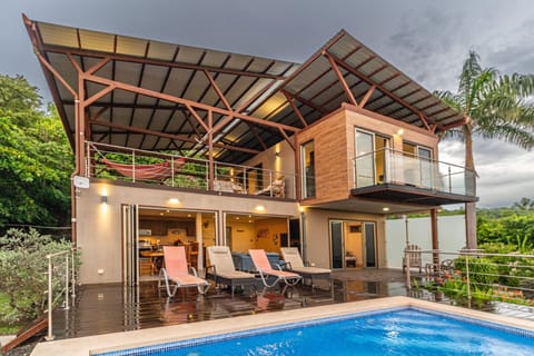 Modern two-story home with poolside lounge and tropical ocean views