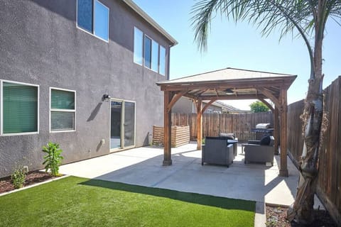 Beautiful backyard and gazebo with outdoor dining, fire pit, and BBQ with propane.