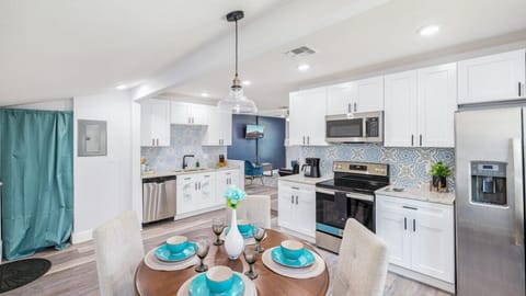 This kitchen features functional cabinets that provide ample storage space for your kitchen essentials and appliances. Additionally, the same space includes a dining area with seating for four.