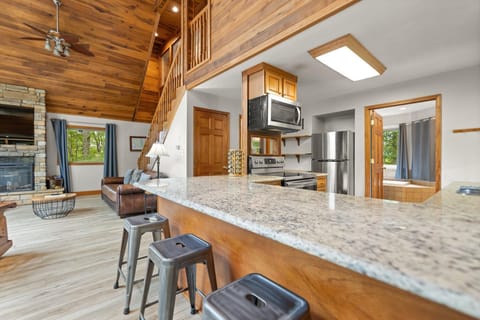 Spacious kitchen with granite countertops and cozy stone fireplace with electric insert.