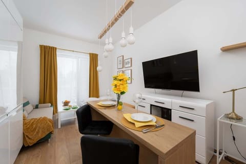 A modern sofa with mustard yellow cushions adds a pop of color to the bright living space.