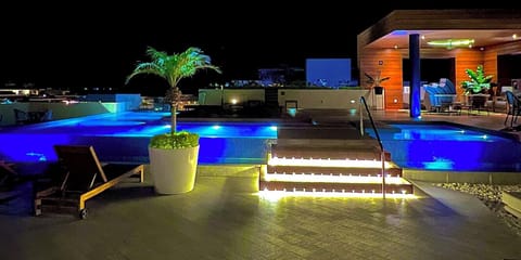 Rooftop infinity pool with 360 degree views at night