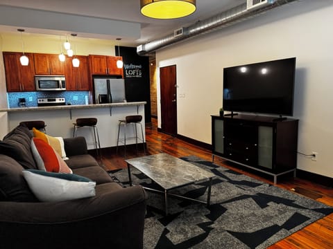 Exposed brick, hardwood floors, and sunlit windows create a warm, inviting vibe.